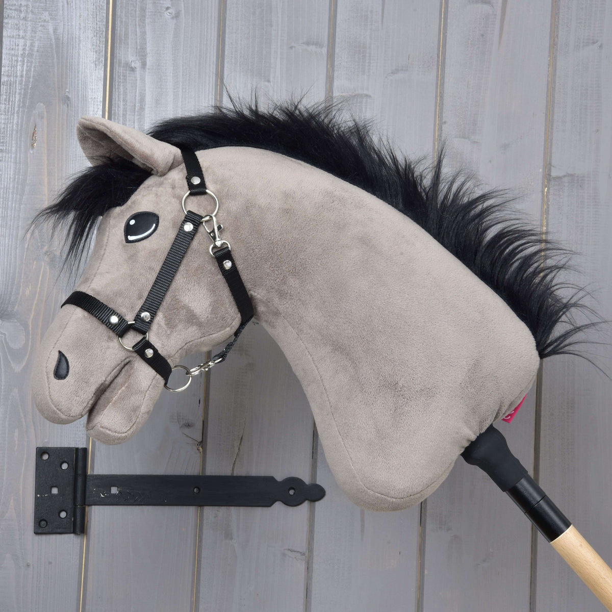Hobby Horse konj Thor v levem profilu s puhasto črno grivo vzdolž sivo rjavega vratu in črno oglavko