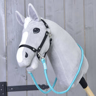 Svetlo siv Hobby Horse konj s črno oglavko in turkiznimi vajetmi Atlantis, ovitimi okoli vratu