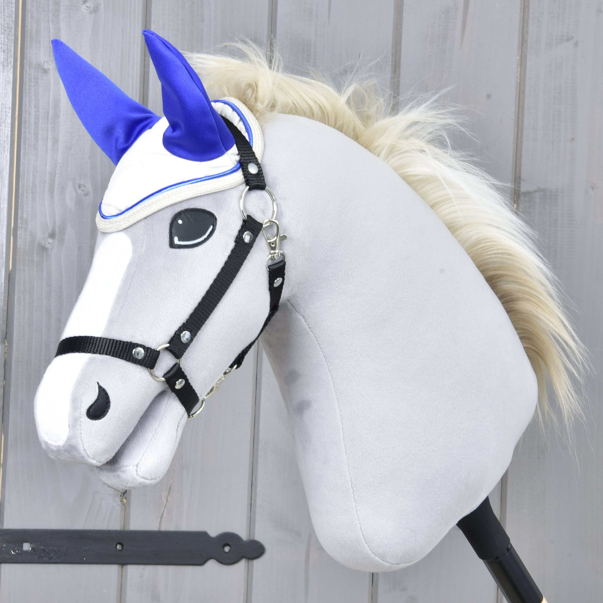 Siv Hobby Horse konj z blond grivo in črno oglavko nosi naušnike Cream Pearl z živo kraljevsko modrimi ušesi