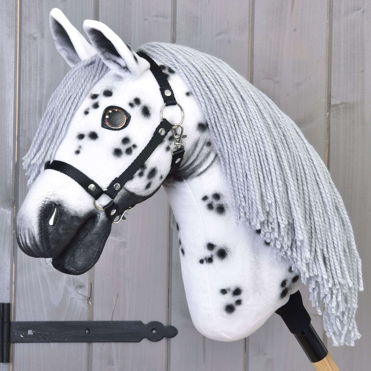 Hobby Horse Chantal s črno oglavko znamke LarDen: bela plišasta glava s črnimi pikami in dolgo sivo grivo iz preje