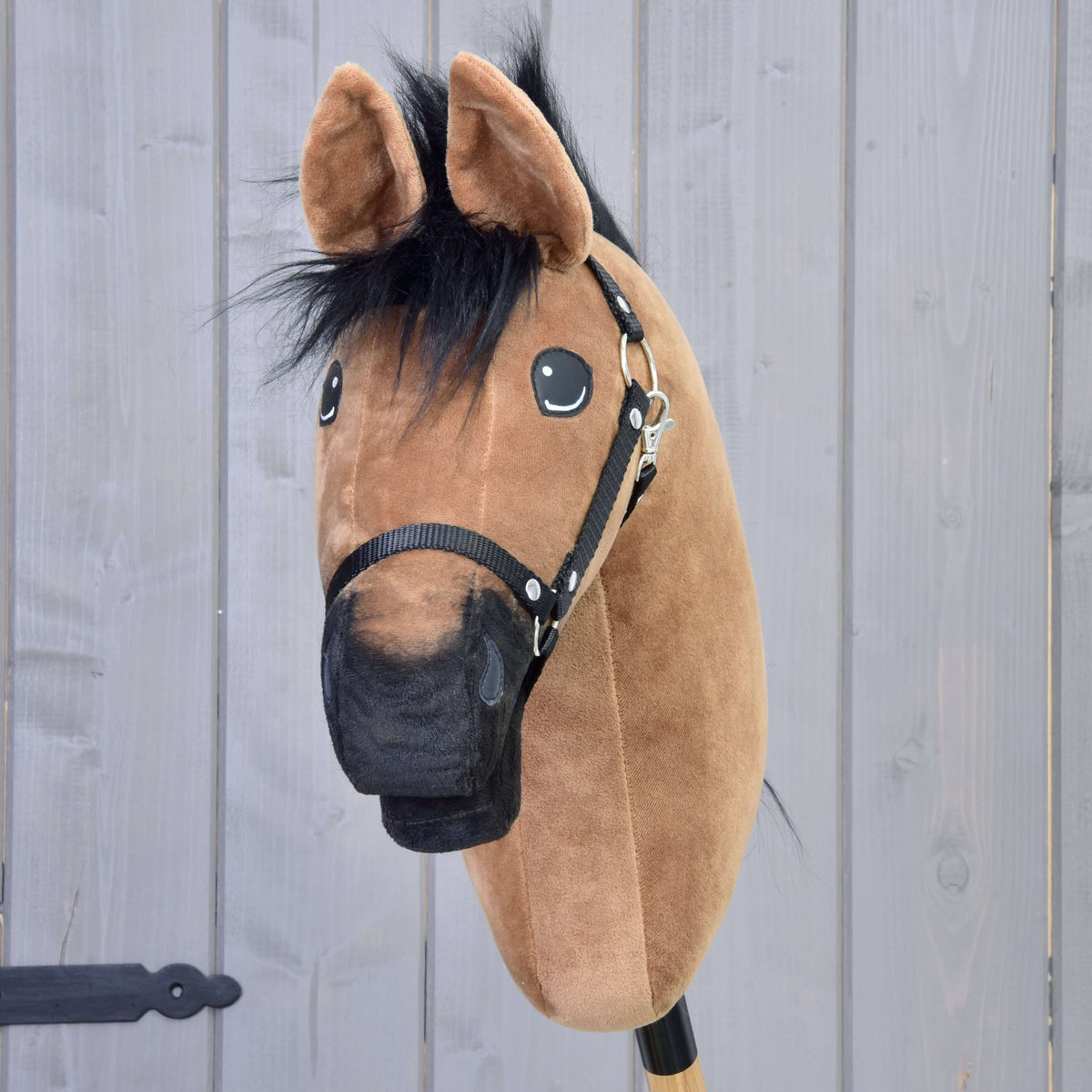 Svetlo rjav Hobby Horse konj od spredaj s črnim krznenim čopom, črnim gobcem in črno oglavko