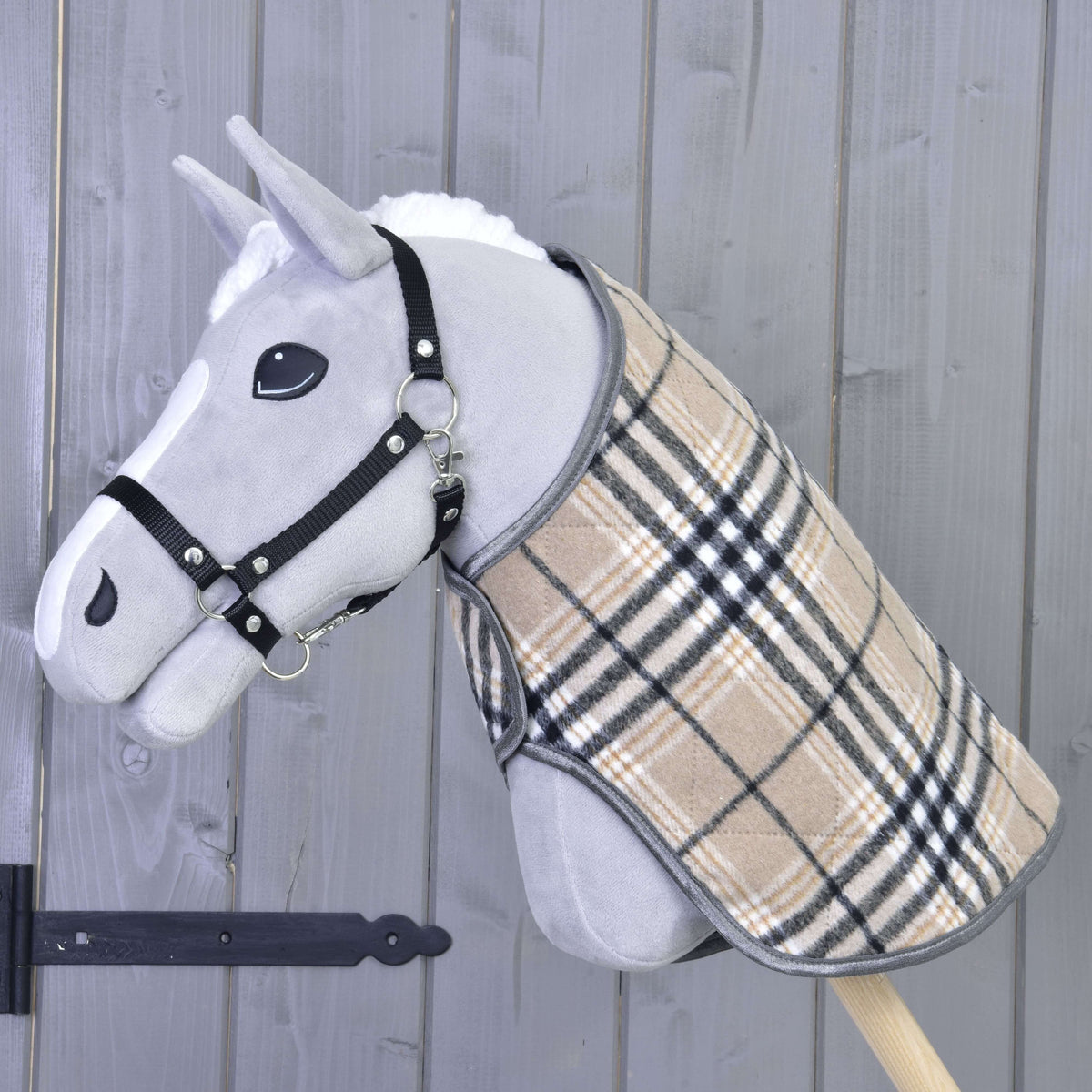 Light grey Hobby Horse in a black halter wearing the beige check blanket with black and white stripes
