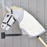 Siv Hobby Horse konj s črno oglavko nosi čez vrat pregrinjalo Cream Pearl iz smetanastega prešitega blaga s kraljevsko modrim paspulom