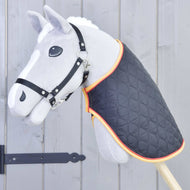 Siv Hobby Horse konj s črno oglavko, oblečen v črno prešito pregrinjalo z zlato in rdečo obrobo ob vratu