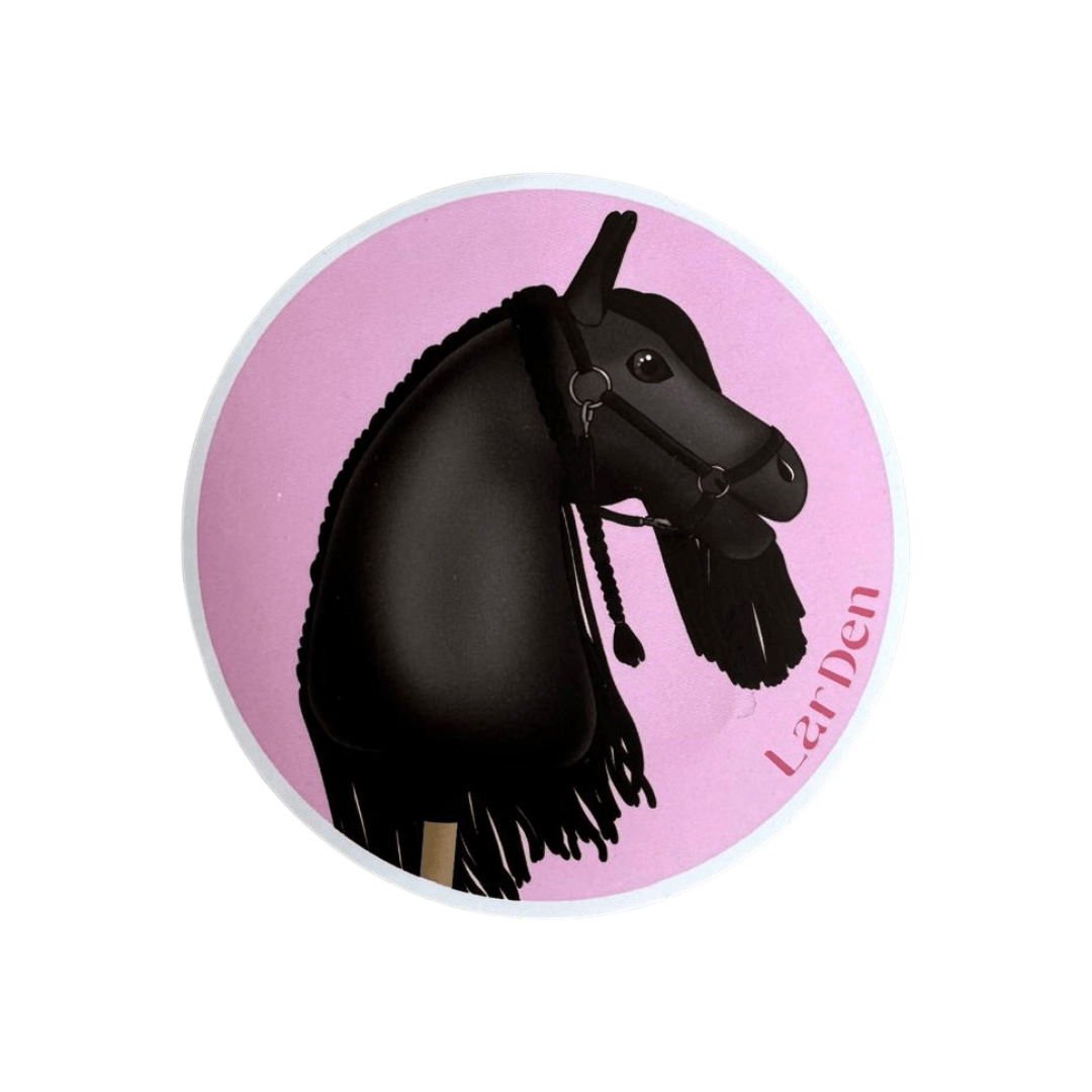 Round sticker with a black Hobby Horse with braided mane and bridle on a pink background, signed LarDen in pink
