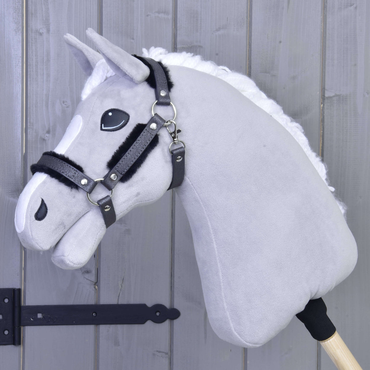 Svetlo siv Hobby Horse konj z belo grivo in bleščečo grafitno oglavko s črnim krznom na nosniku in ličnih jermenih