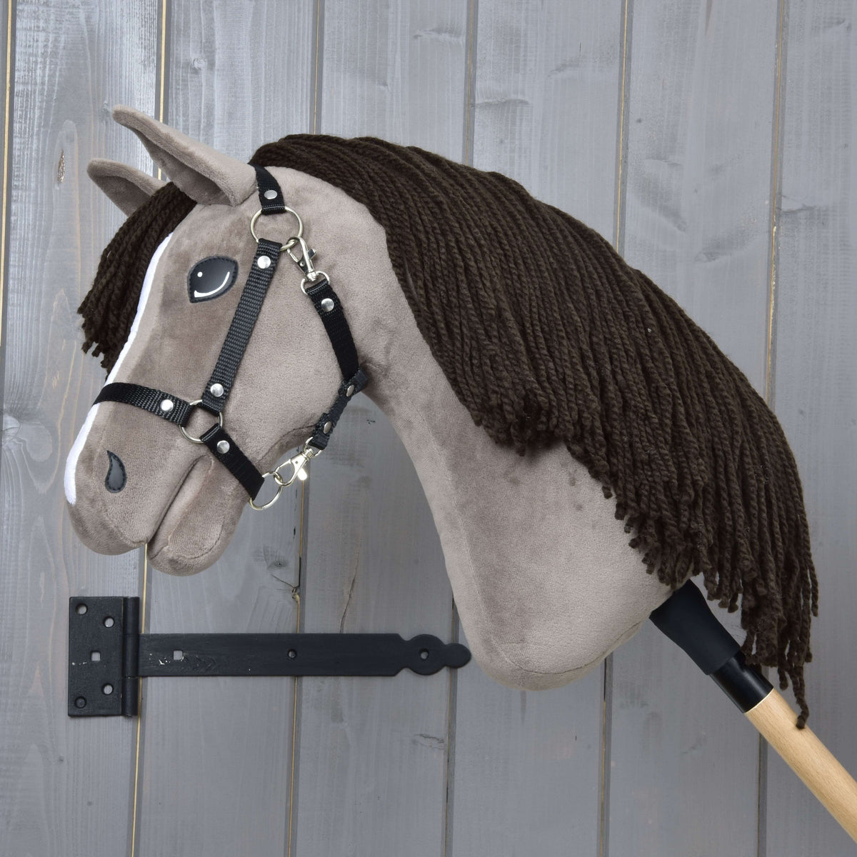 Hobby Horse Guccini in left profile with the long dark brown yarn mane covering the neck and a black halter