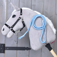 Svetlo siv Hobby Horse konj s črno oglavko in pripetim svetlo modrim povodcem Heaven, prevešenim čez vrat