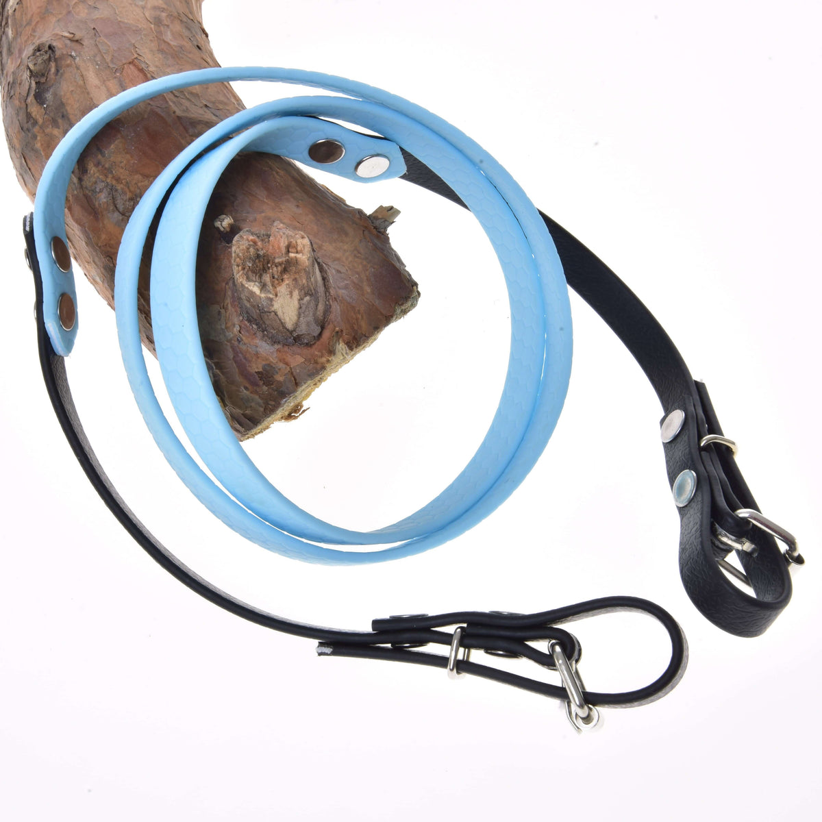 Hobby Horse Reins rubberized Light blue by LarDen, light blue middle and black buckle ends, looped over a pine branch