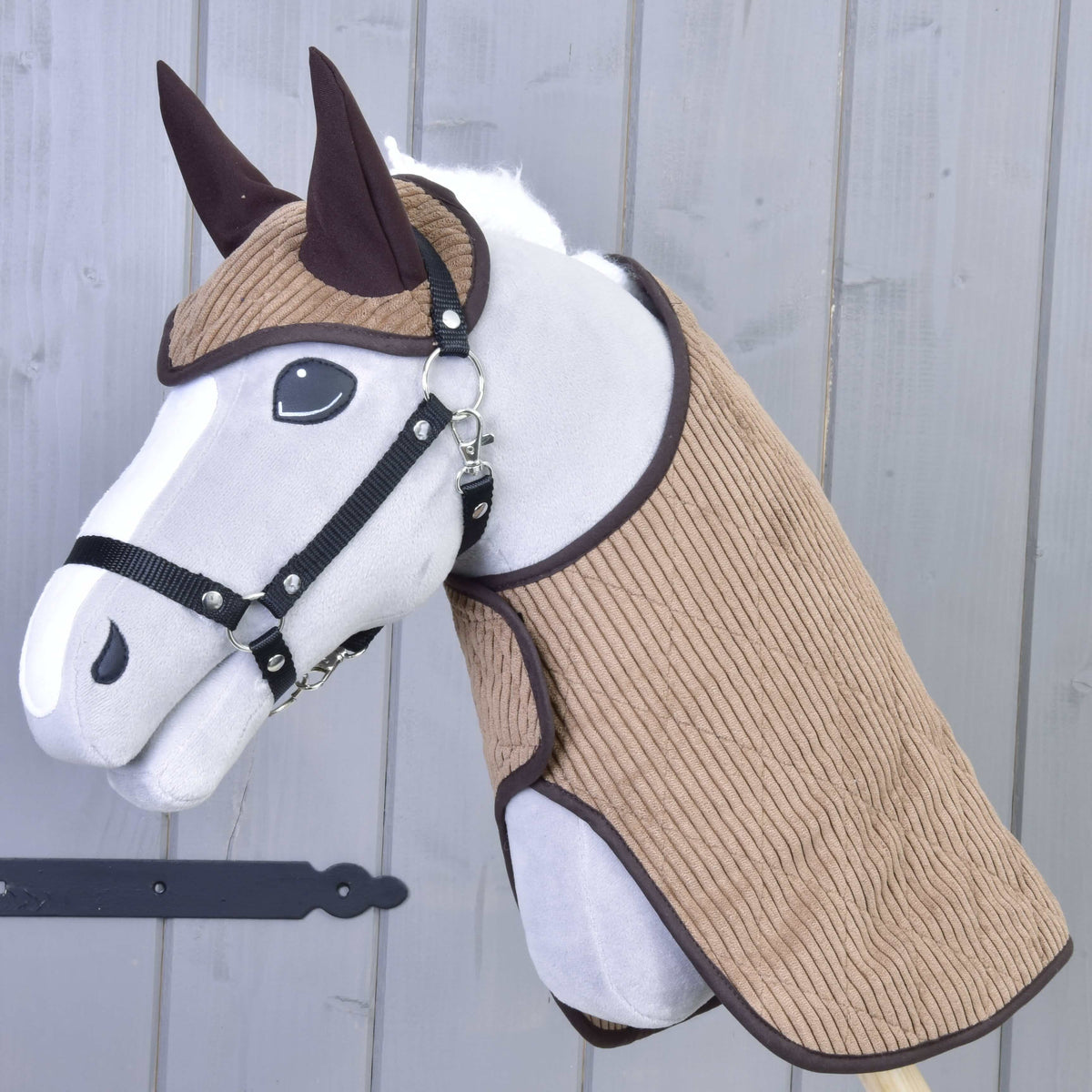 Siv Hobby Horse konj s črno oglavko, oblečen v svetlo rjavo pregrinjalo iz rebrastega žameta in naušnike s temno rjavo obrobo