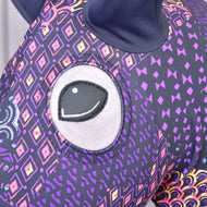 Bližnji posnetek odprtine za oko na vijolično-črni obleki Mandala z roza, rumenimi in vijoličnimi rombastimi motivi na Hobby Horse konju