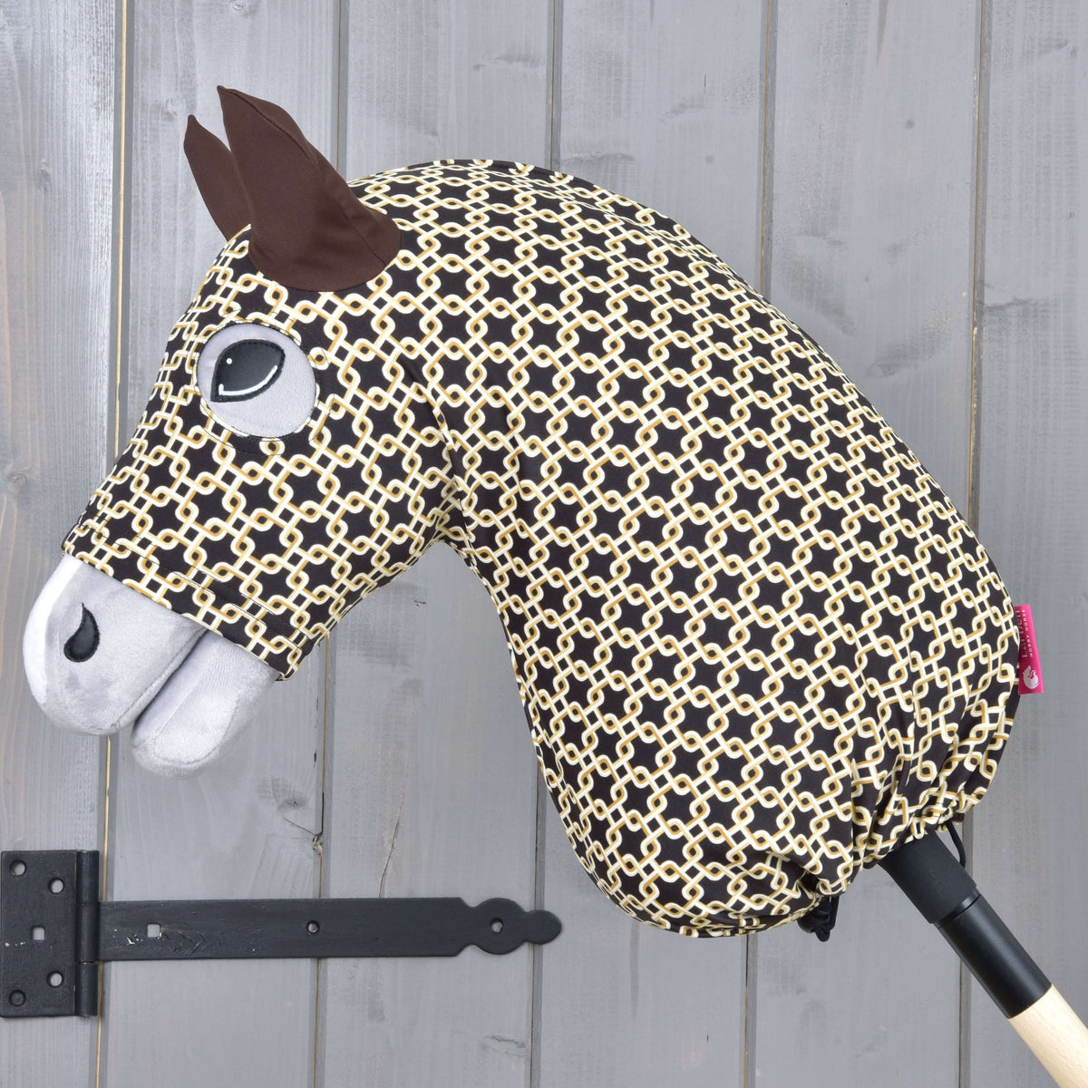 Hobby Horse zaščitna obleka Luxus Design znamke LarDen v temno rjavi barvi s smetanastim potiskom verižnih členov na sivem Hobby Horse konju