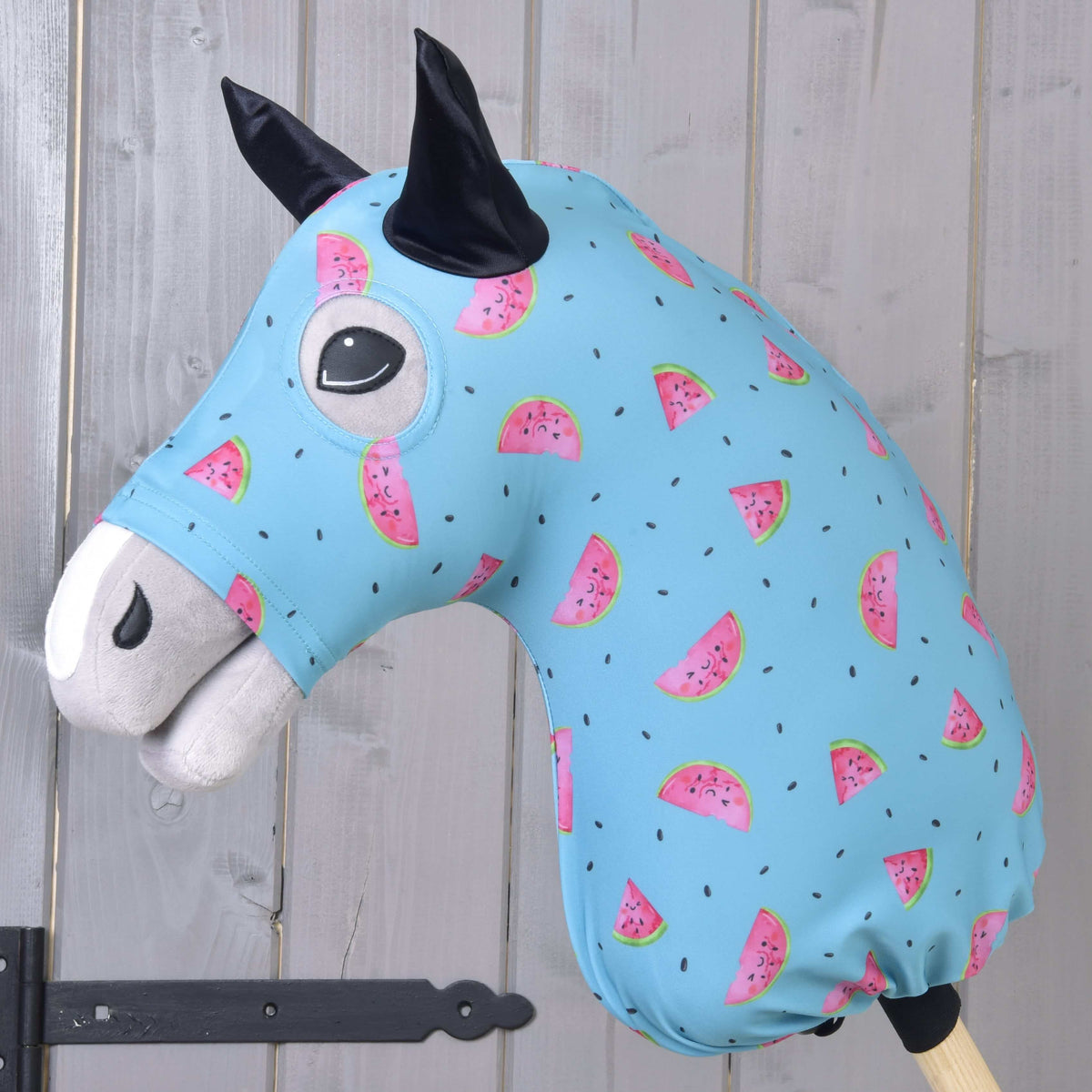 Hobby Horse zaščitna obleka Melon (Lycra) znamke LarDen, svetlo modra z nasmejanimi rezinami lubenice, poveznjena čez sivo glavo