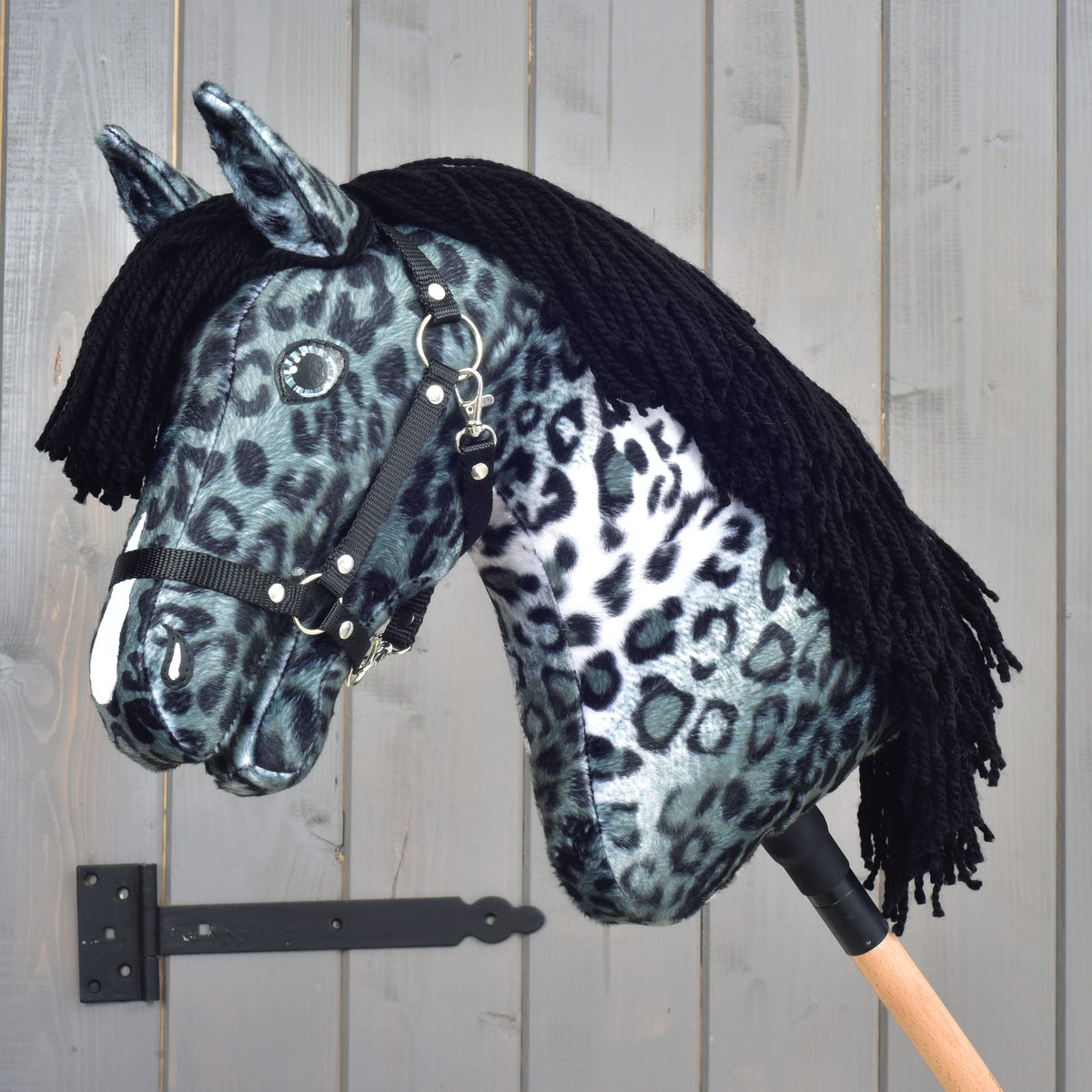 Hobby Horse Picasso s črno oglavko znamke LarDen: siv leopardje pikast pliš z belo liso in dolgo črno grivo iz preje