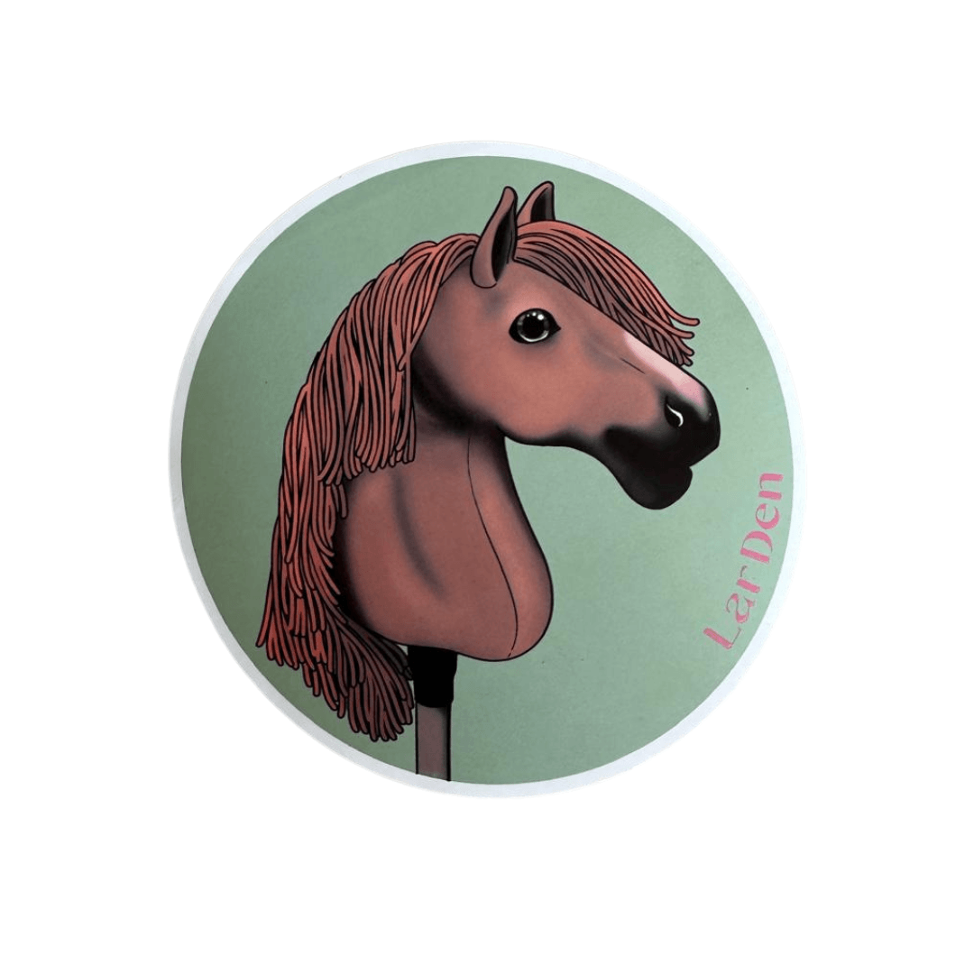 Sticker with a chestnut Hobby Horse with a long reddish mane and dark muzzle on a sage green circle, with LarDen in pink