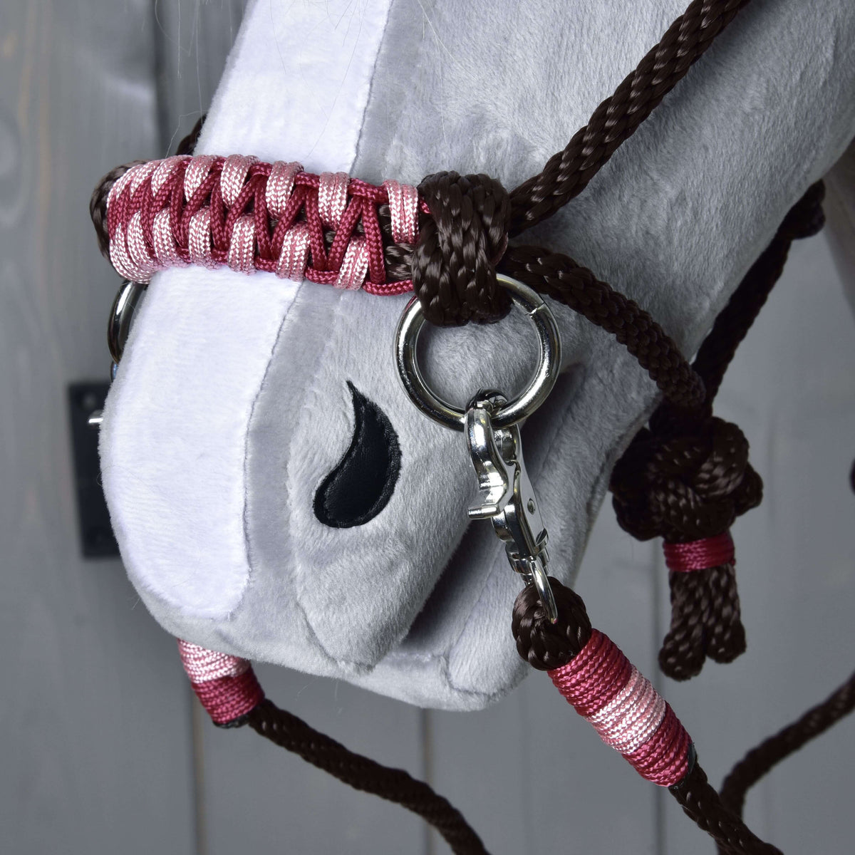 Close-up of the Rope set York noseband braided in burgundy and pink, with a silver ring, snap hook and dark brown rope