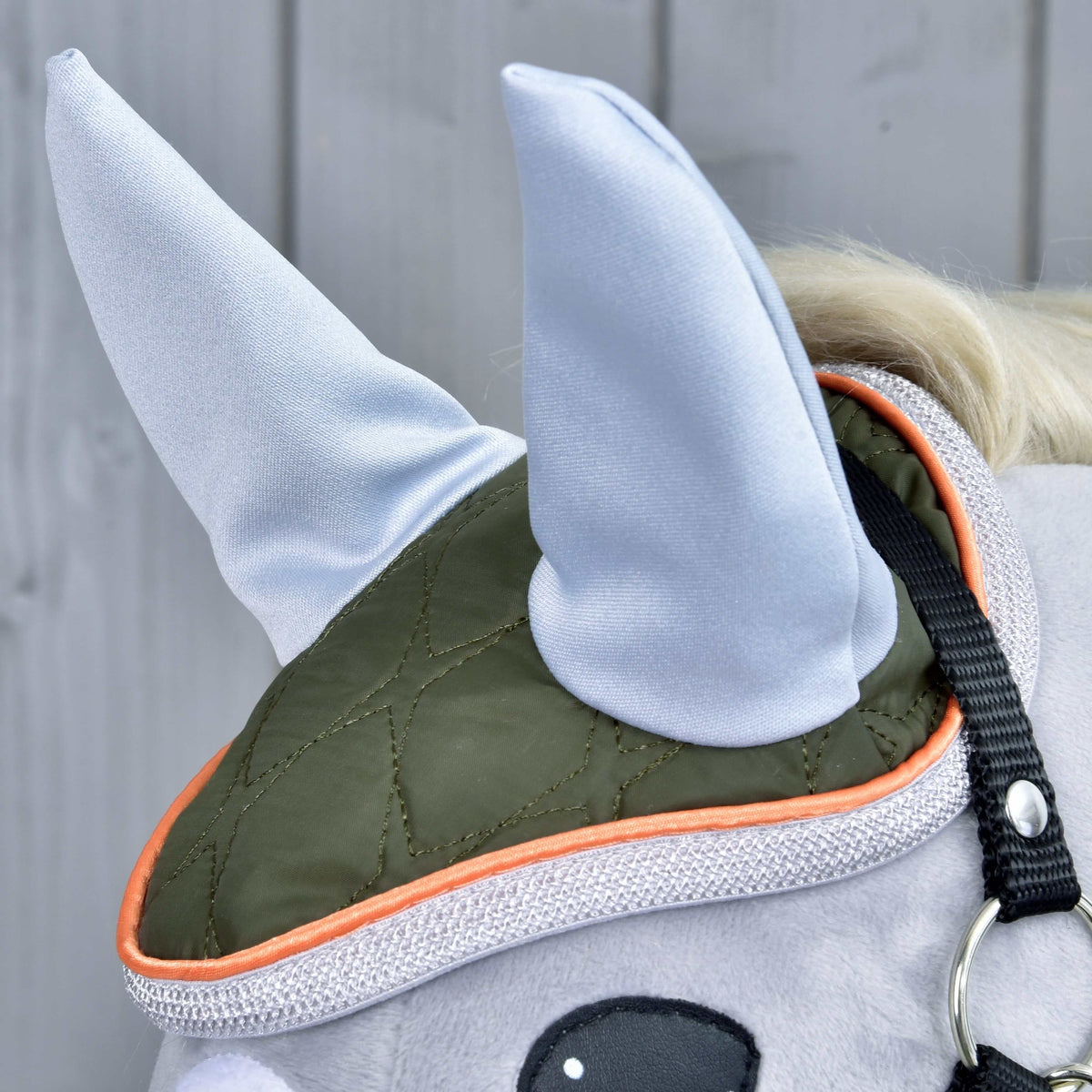 Close-up of the Set Moos ear bonnet with light grey ears, olive quilting and a silver and orange edge