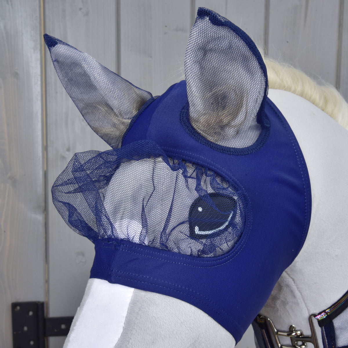 Close-up of the Set Fly Combo fly mask on a grey Hobby Horse: navy fabric with mesh ears and a gathered mesh eye cover