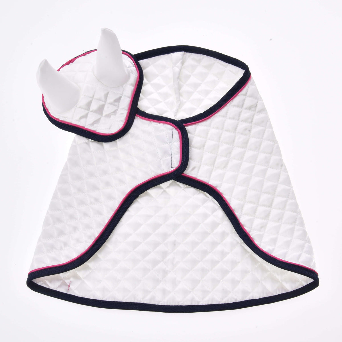 The white quilted blanket and ear bonnet laid open from above, showing the front closure and navy and pink edging