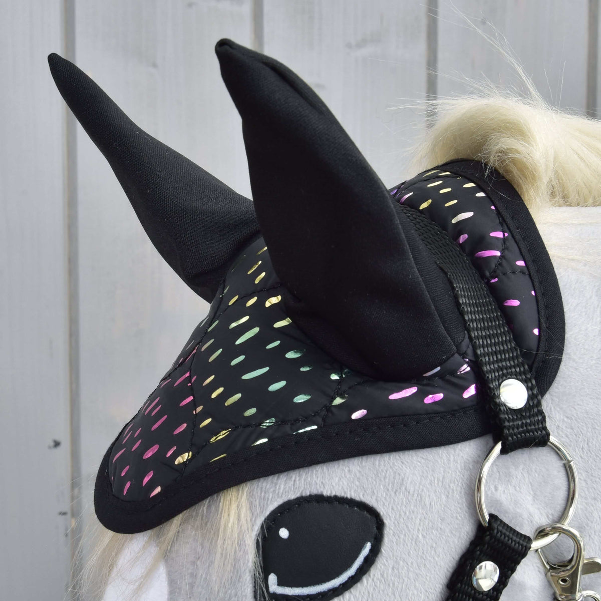 Close-up of the Set Dreamy ear bonnet with tall black ears and shimmering rainbow dots, over a black halter