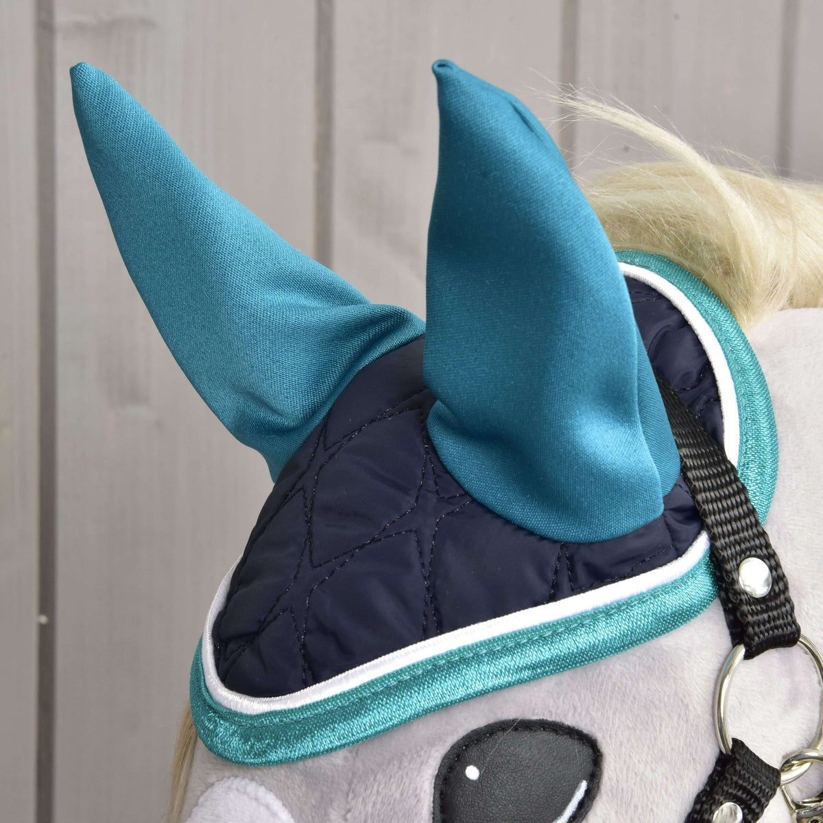 Close-up of the Set Supreme Turquoise ear bonnet: quilted navy crown, satin turquoise ears and white piping