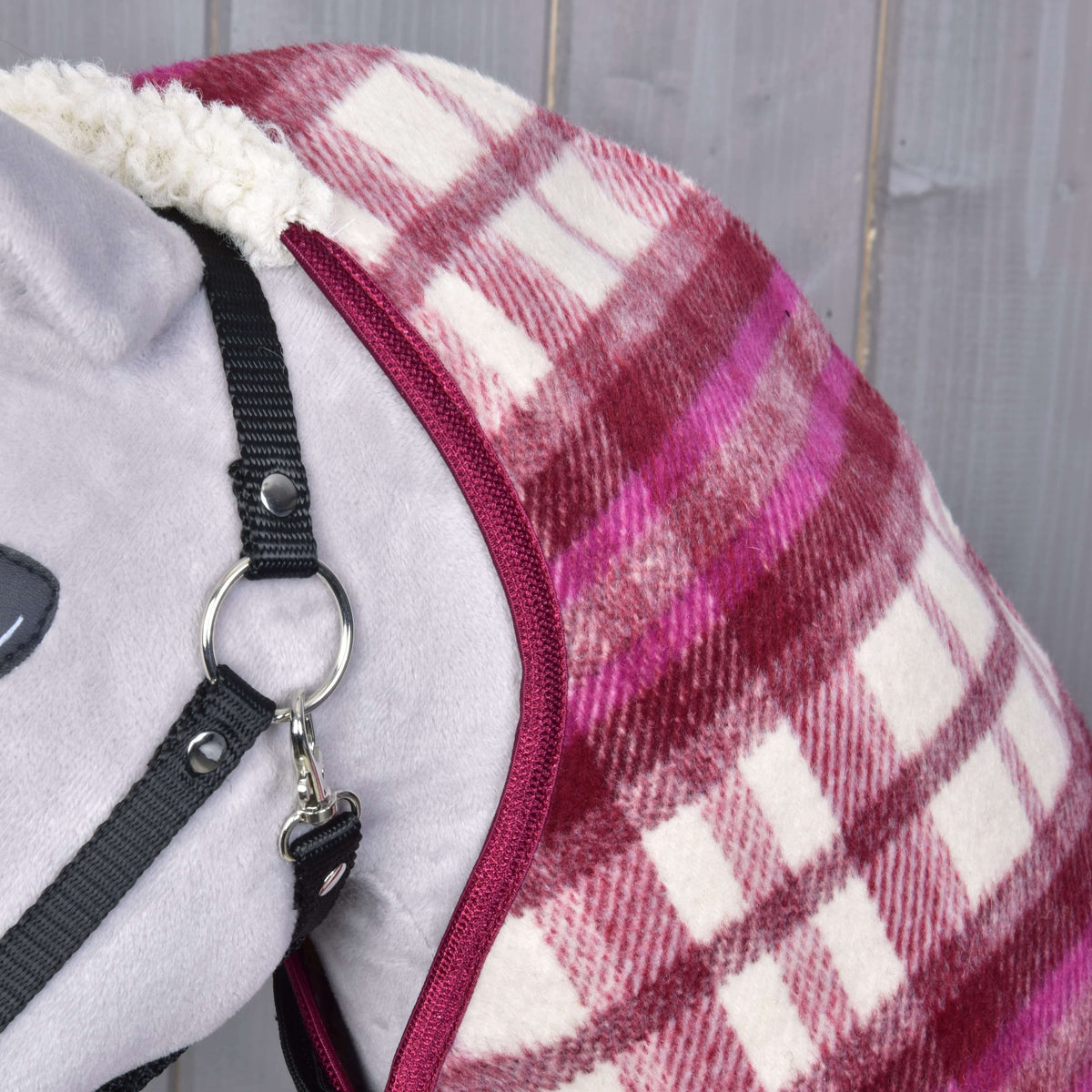 Close-up of the burgundy binding and the pink and cream check fabric along the neck of a grey Hobby Horse