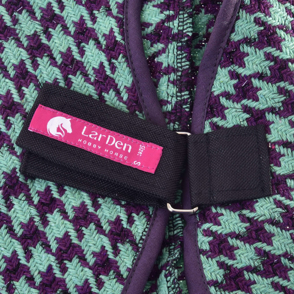 Close-up of the pink LarDen label on the Hobby Horse Stable Blanket Green strap, mint and purple weave with glitter