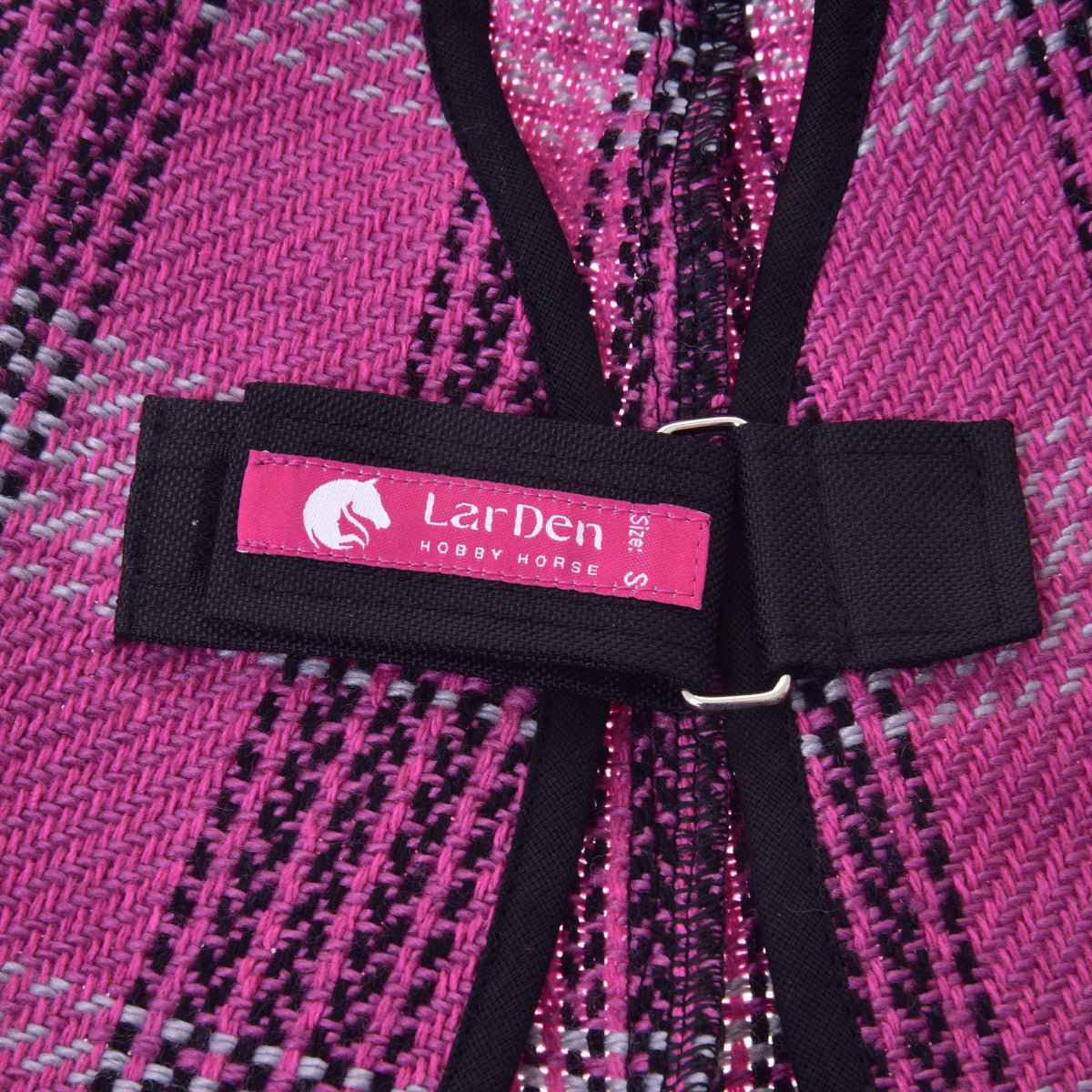 Close-up of the pink LarDen label on the black chest strap of the Hobby Horse Stable Blanket Pink, set on the woven plaid
