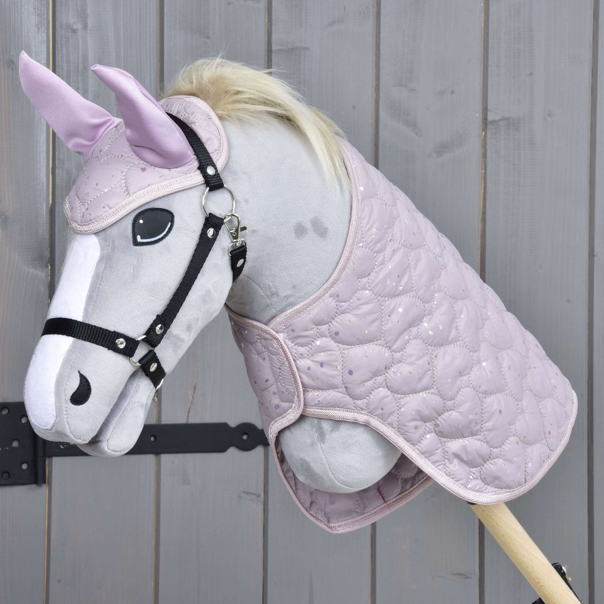 Light grey Hobby Horse with a black halter wearing the Set Sweetest Heart, a lilac quilted blanket and ear bonnet