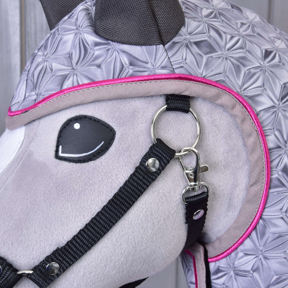 Close-up of the hot pink piping around the face opening of the Raincoat Valentine next to the black halter and snap hook
