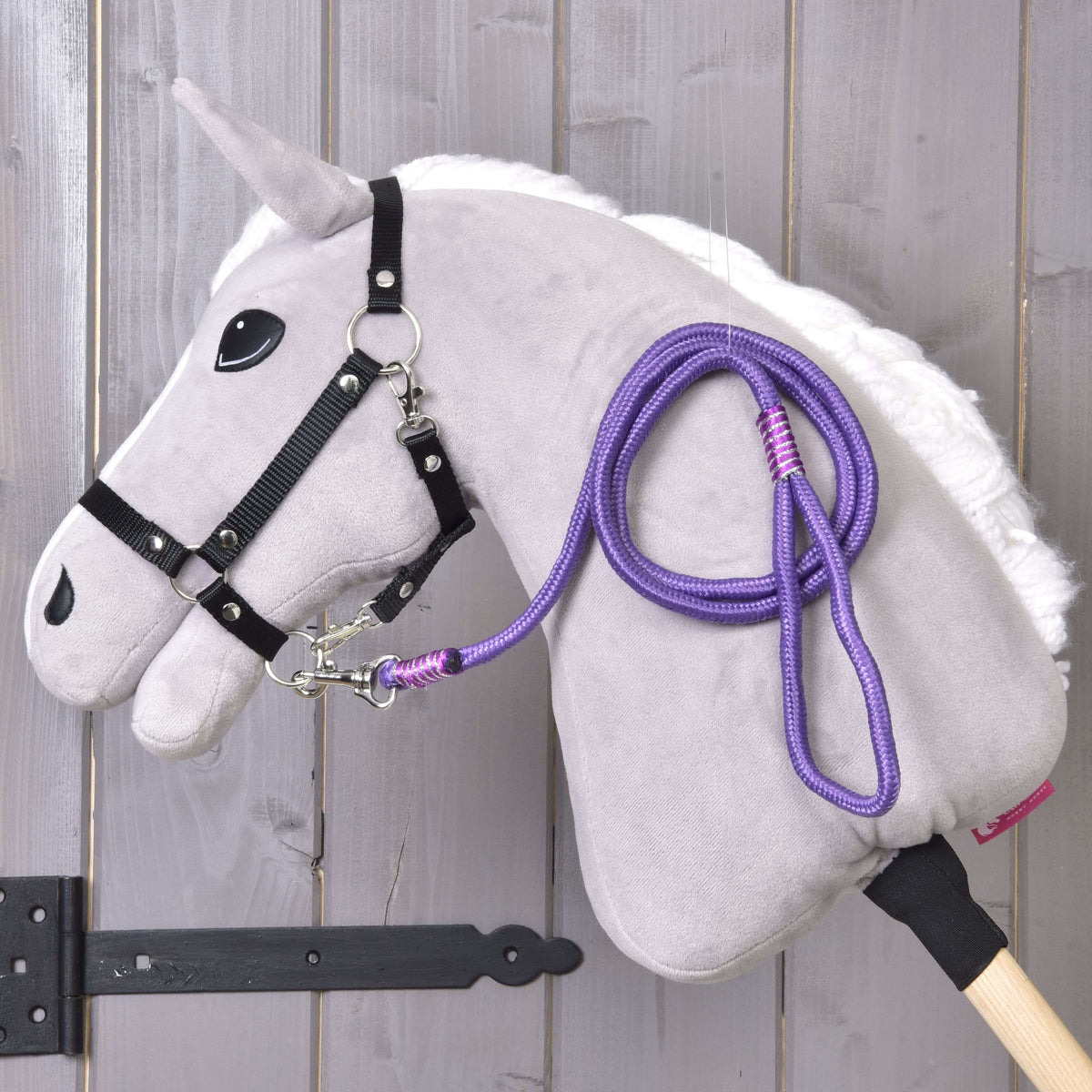 Svetlo siv Hobby Horse konj s črno oglavko in vijoličnim povodcem Viola, obešenim čez vrat