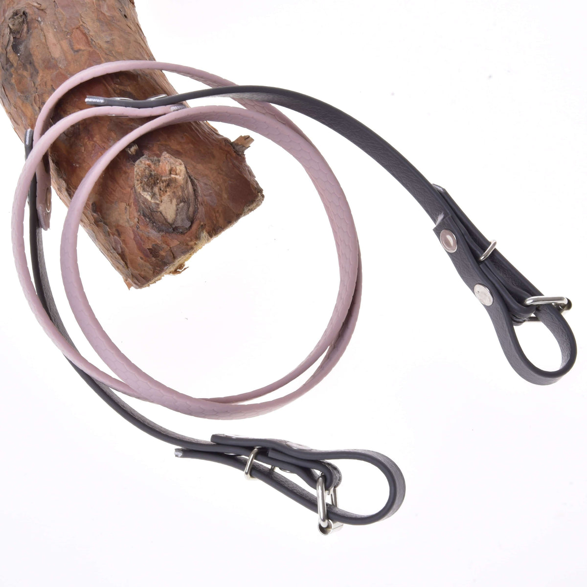 Hobby Horse Reins rubberized Dark Grey/Pink by LarDen, pale pink middle and dark grey buckle ends, looped over a branch