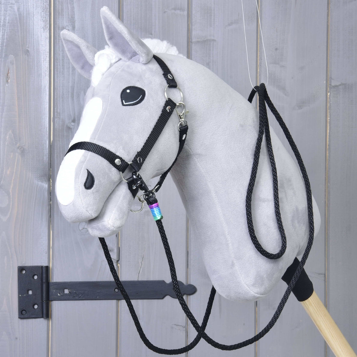 Grey Hobby Horse in a black halter with the black western reins clipped to both sides and looped up over the neck